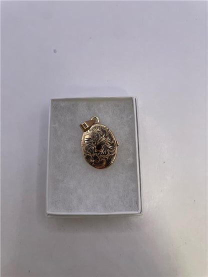 9ct yellow gold locket weighing 3.5g, unbranded, with intricate design, displayed on a white background.