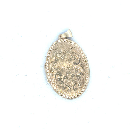 9ct yellow gold locket pendant weighing 6.3g, unbranded, with a polished finish and detailed engraved design.