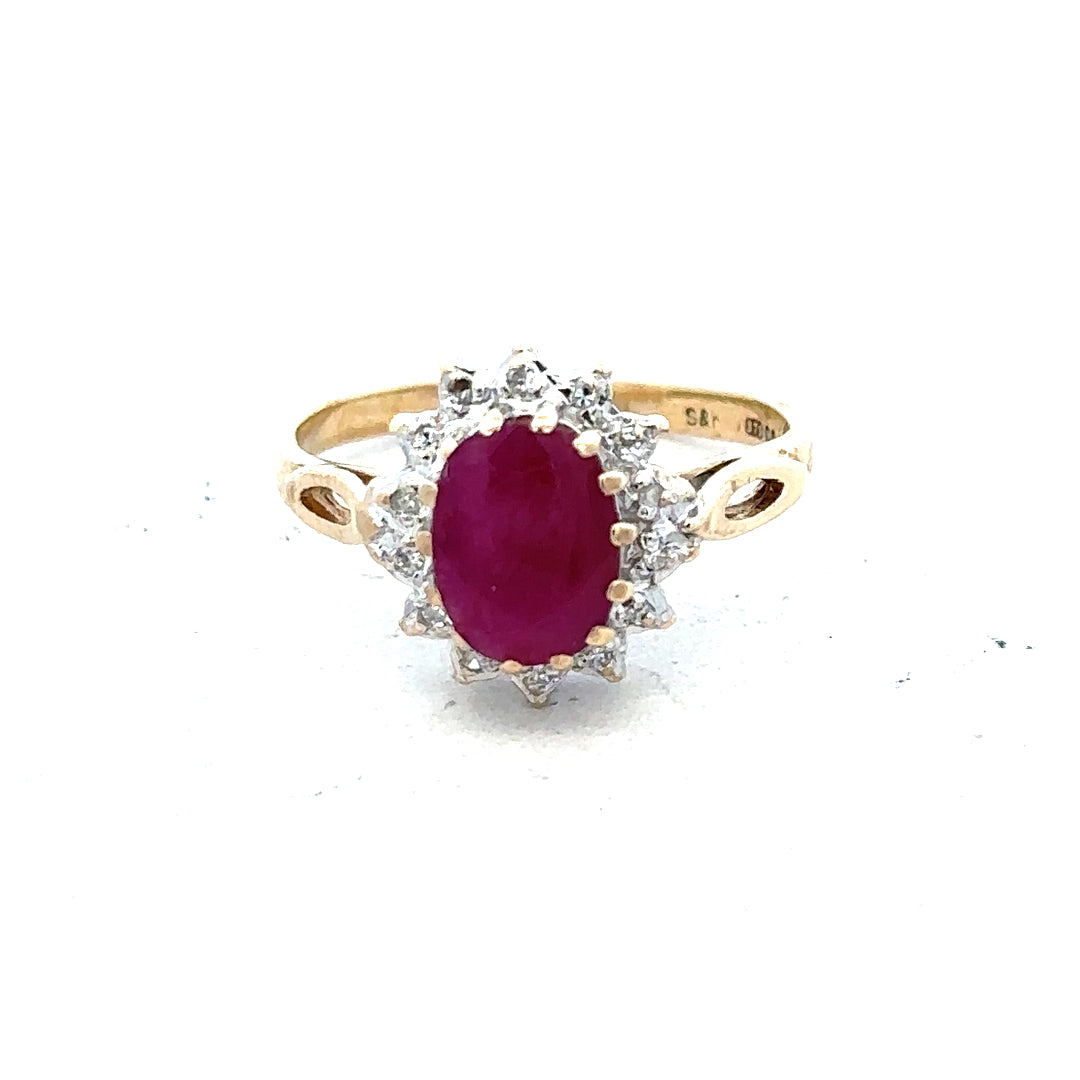 9ct yellow gold ruby and diamond ring in size L, featuring a central ruby surrounded by sparkling diamonds, elegant jewelry design.
