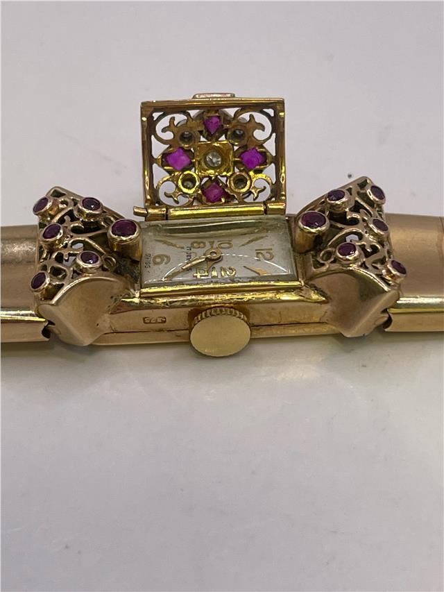 9ct yellow gold ruby and diamond watch with a sleek design, showcasing a gold watch face and embedded gemstones.