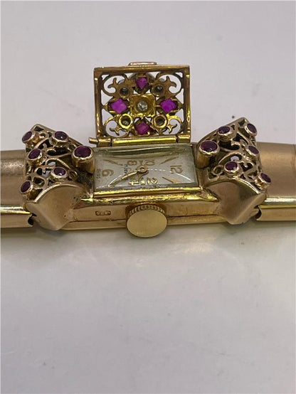 9ct yellow gold ruby and diamond watch with a sleek design, showcasing a gold watch face and embedded gemstones.