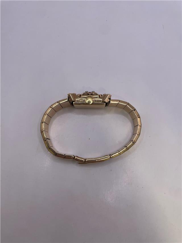 9ct yellow gold ruby and diamond watch with a sleek design, featuring a round face and elegant bracelet.