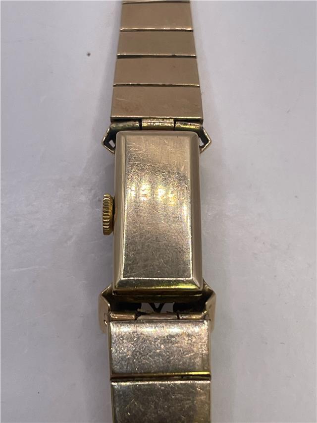 9ct yellow gold ruby and diamond watch with a sleek design, featuring a gold bracelet and elegant face.