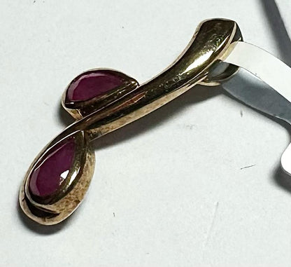 9ct yellow gold ruby pendant with a small gemstone, weighing 1.2g, showcasing elegant jewelry design.