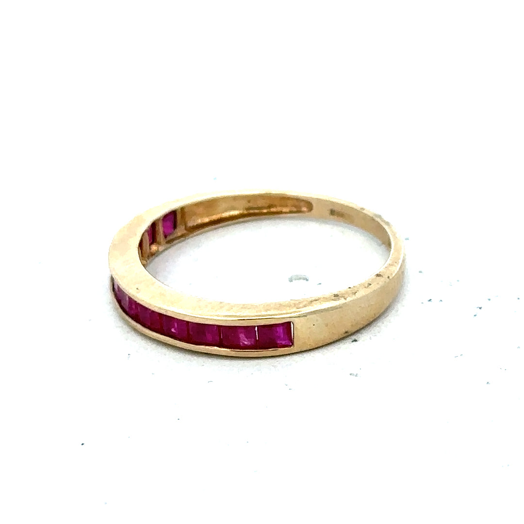 9ct yellow gold ruby ring size P1/2 with a central red ruby gemstone, featuring a simple gold band design.