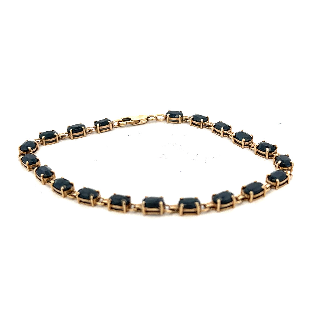 9ct yellow gold sapphire bracelet with intricate design, weighing 8.2g, showcasing vibrant blue sapphires on a delicate gold band.