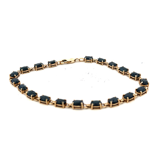 9ct yellow gold sapphire bracelet with intricate design, weighing 8.2g, showcasing vibrant blue sapphires on a delicate gold band.