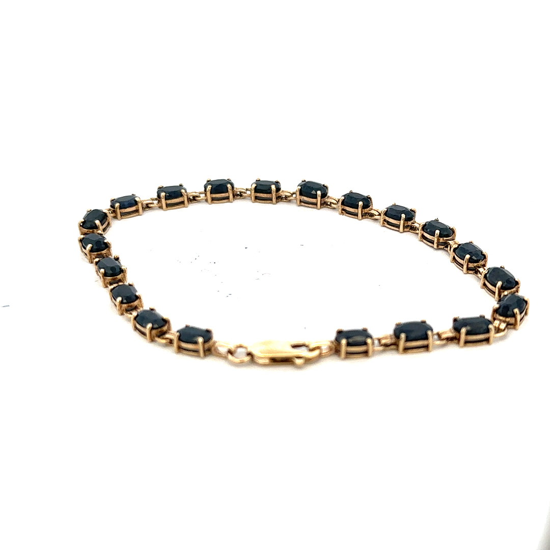 9ct yellow gold sapphire bracelet with a delicate chain, showcasing vibrant blue sapphires and elegant craftsmanship.