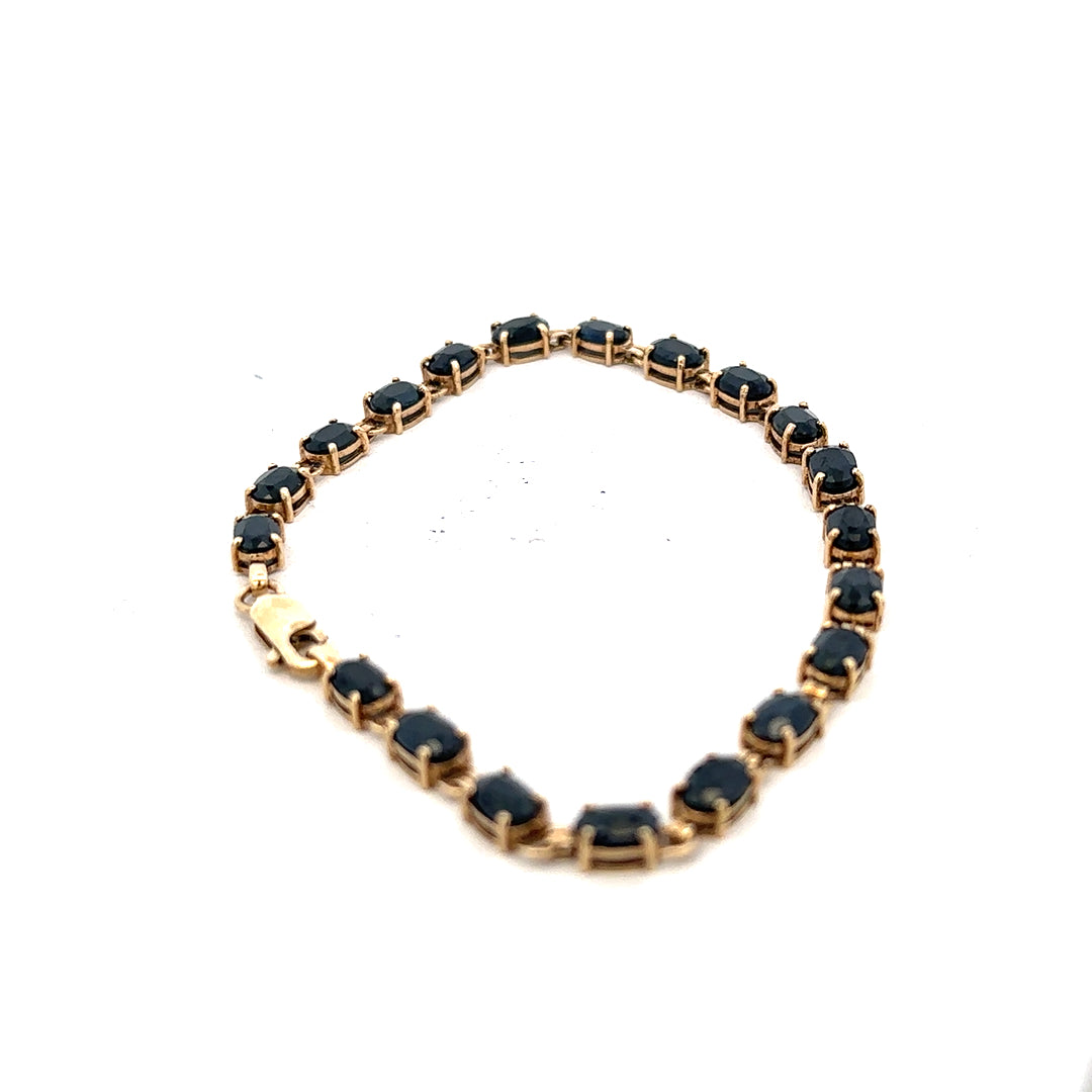 9ct yellow gold sapphire bracelet with intricate design, weighing 8.2g, featuring vibrant blue sapphires on a delicate gold chain.