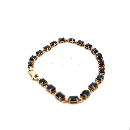 9ct yellow gold sapphire bracelet with intricate design, weighing 8.2g, featuring vibrant blue sapphires on a delicate gold chain.