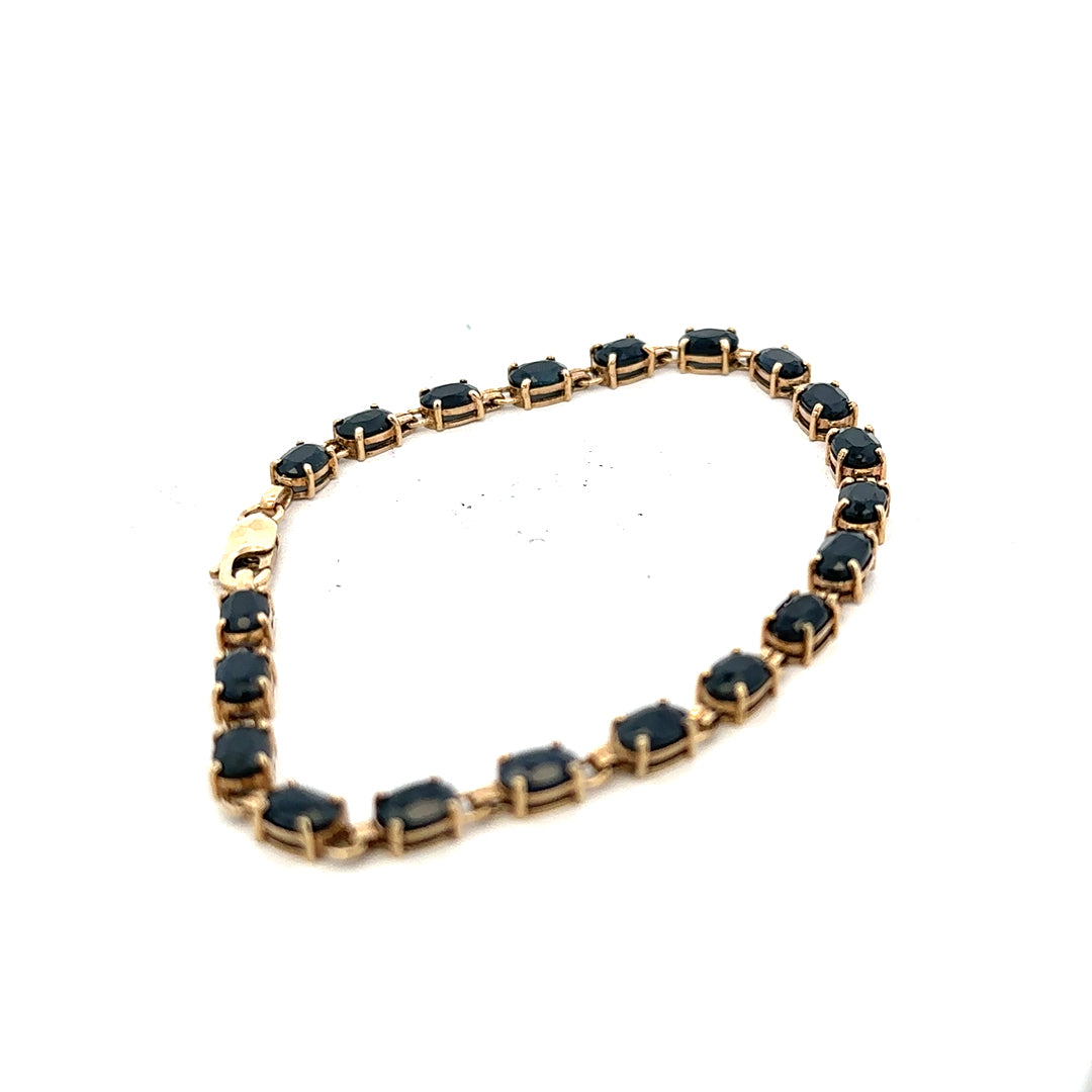 9ct yellow gold sapphire bracelet with intricate design, weighing 8.2g, featuring vibrant blue sapphires on a delicate gold band.