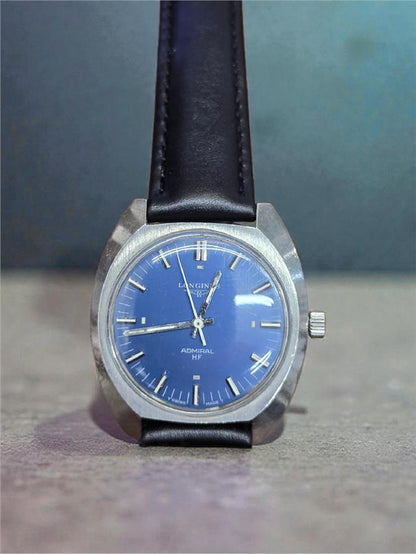 Longines 1972 Munich Olympics watch with gold-tone case and black leather strap, detailed dial featuring Olympic logo and chronograph functions.