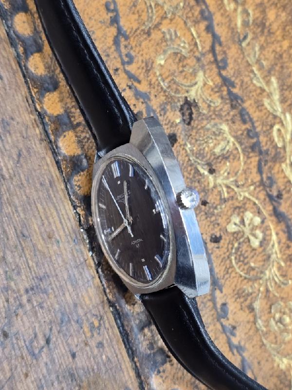 Longines 1972 Munich Olympics vintage watch with gold-tone case and black leather strap, featuring Olympic logo on dial.