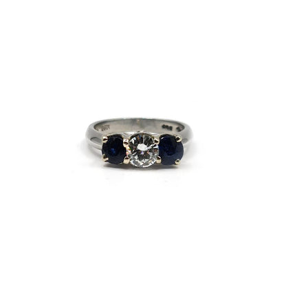 Platinum ring featuring a 1/2 carat diamond and 0.80 carat sapphire, elegant jewelry with a sleek band design.