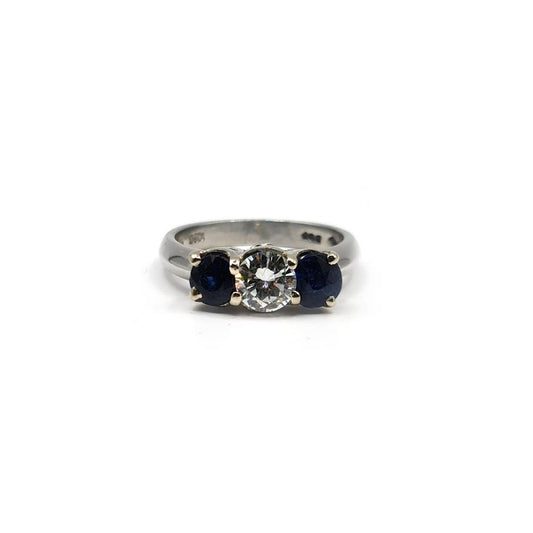 Platinum ring featuring a 1/2 carat diamond and 0.80 carat sapphire, elegant jewelry with a sleek band design.