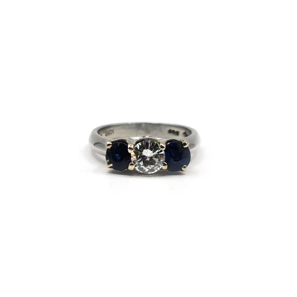 Platinum ring featuring a 1/2 carat diamond and 0.80 carat sapphire gemstone, elegant jewelry with intricate design.