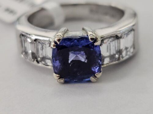 Platinum 1.79 carat tanzanite and 1.60 carat diamond ring with a polished band and intricate gemstone setting.
