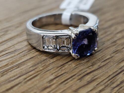 Platinum 1.79 carat tanzanite and 1.60 carat diamond ring with a sleek band and sparkling gemstones.