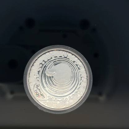 Silver 2000 Olympic coin, 31.4g, unbranded, featuring Olympic design and inscriptions, close-up view showing details and texture.