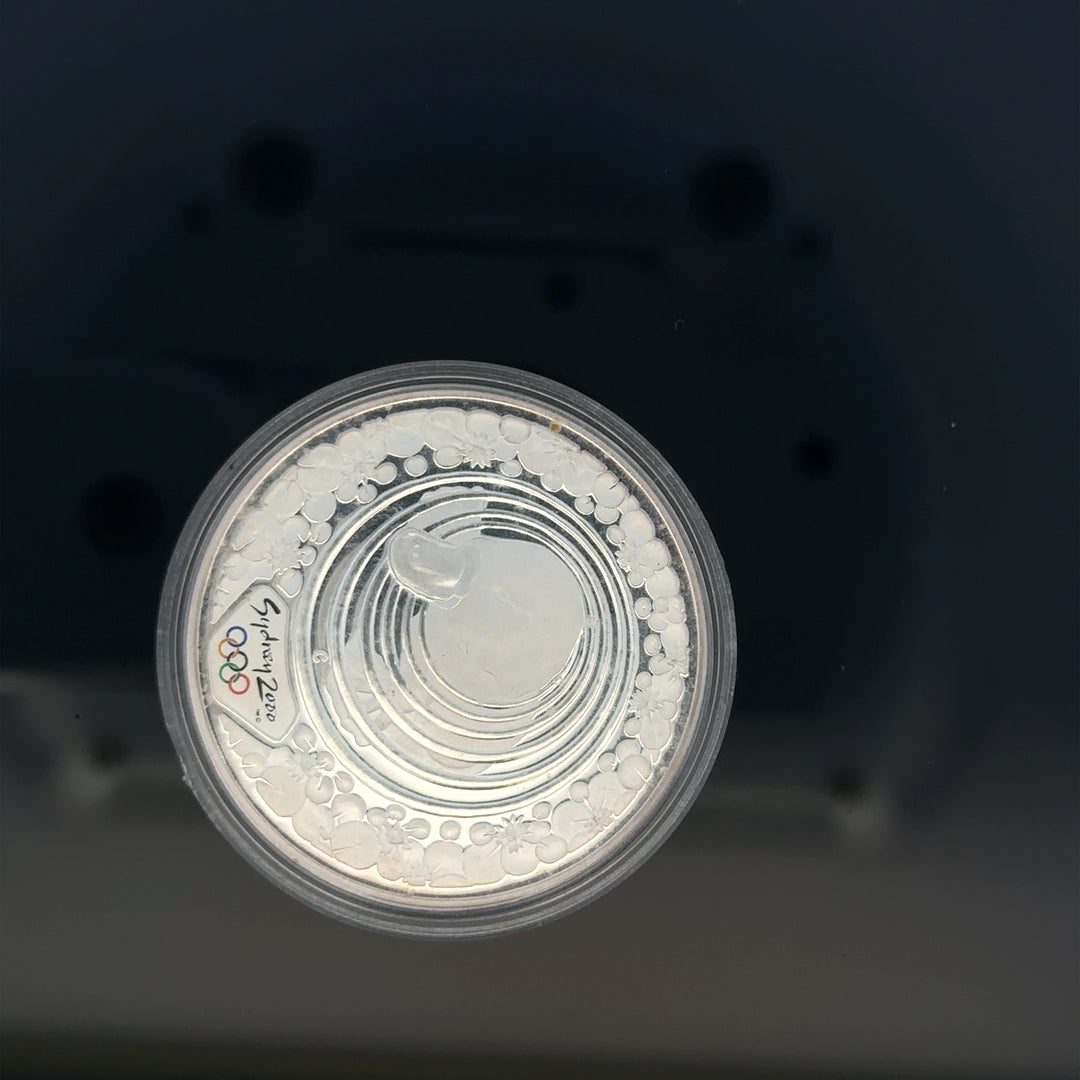 Silver 2000 Olympic coin, 31.4g, featuring Olympic imagery, unbranded collectible coin with detailed design.