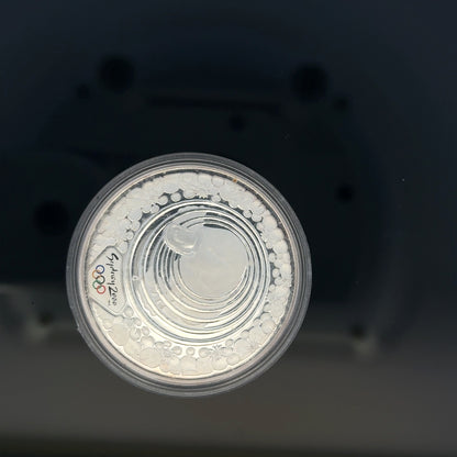 Silver 2000 Olympic coin, 31.4g, featuring Olympic imagery, unbranded collectible coin with detailed design.