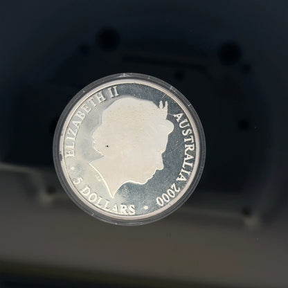 Silver 2000 Olympic coin, 31.4g, unbranded, featuring Olympic design and detailed engravings on a shiny silver surface.