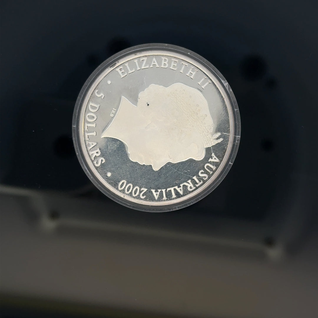 Silver 2000 Olympic coin, 31.4g, unbranded, featuring Olympic designs and inscriptions, shown in close-up image.
