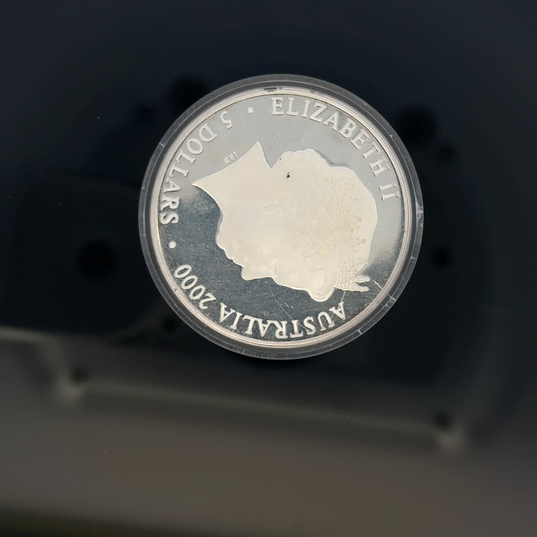 Silver 2000 Olympic coin, 31.4g, featuring Olympic imagery, unbranded collectible coin with detailed design and metallic shine.