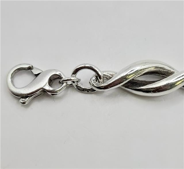 Silver bracelet 19cm, 14.4g, unbranded, with a smooth, polished finish and intricate detailing visible in the image.