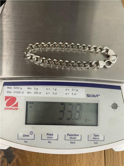 Silver bracelet weighing 33.8g with intricate design, crafted by an unbranded manufacturer, displayed on a plain background.