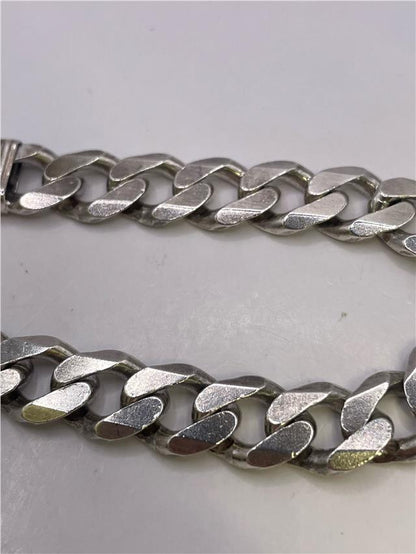 Silver bracelet weighing 34.5g with a sleek design, featuring a shiny finish and adjustable clasp.