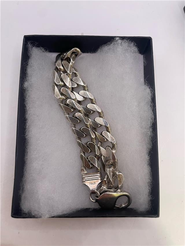 Silver bracelet weighing 34.5g with intricate design, crafted from shiny silver metal, stylish and versatile jewelry accessory.