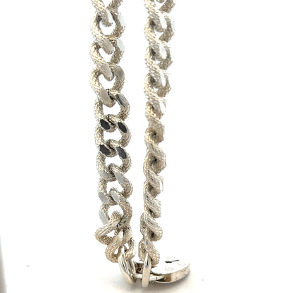 Silver bracelet weighing 64.4g with a sleek, polished design, featuring intricate detailing and a secure clasp.