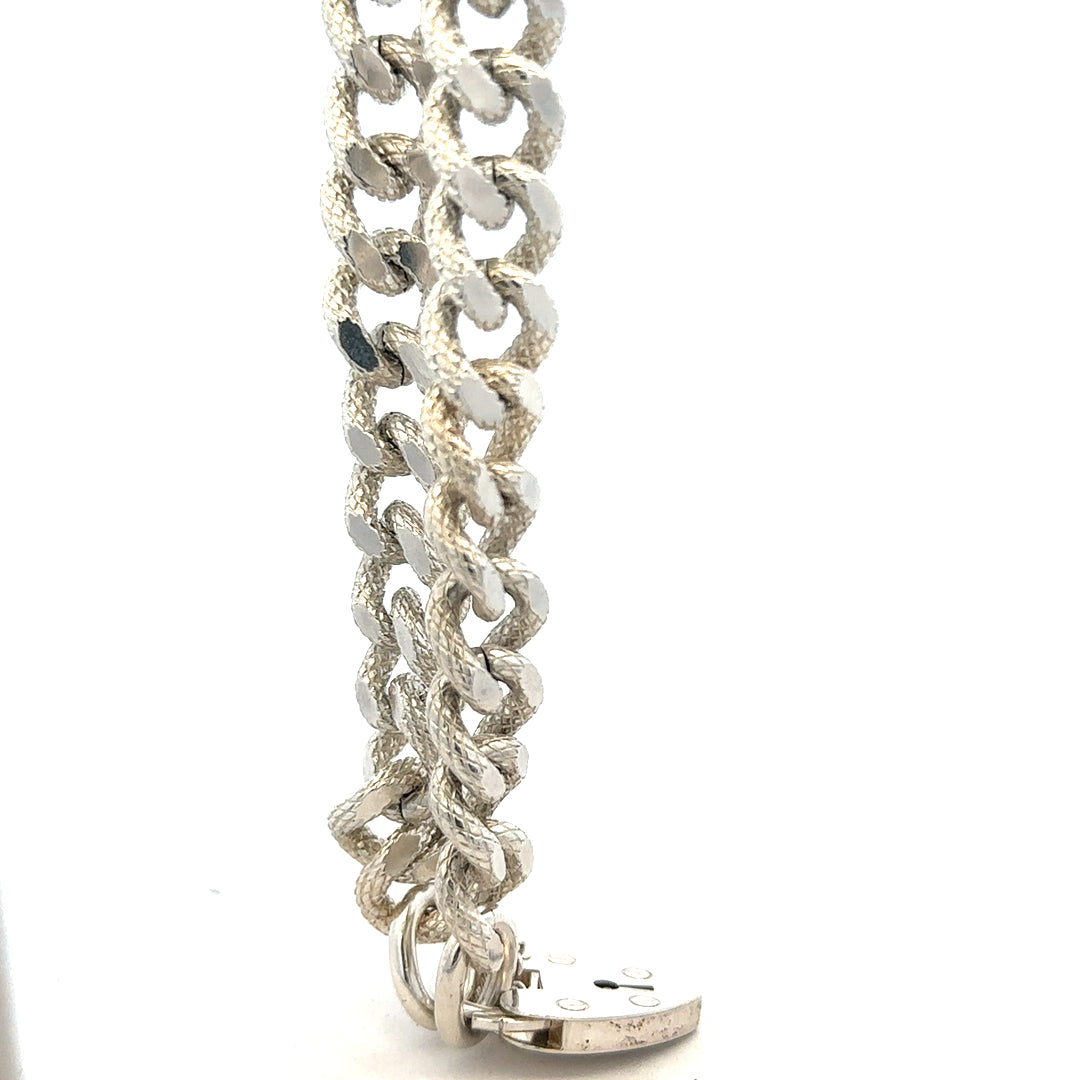 Silver bracelet weighing 64.4g with intricate design, unbranded jewelry piece, shown in a close-up image.