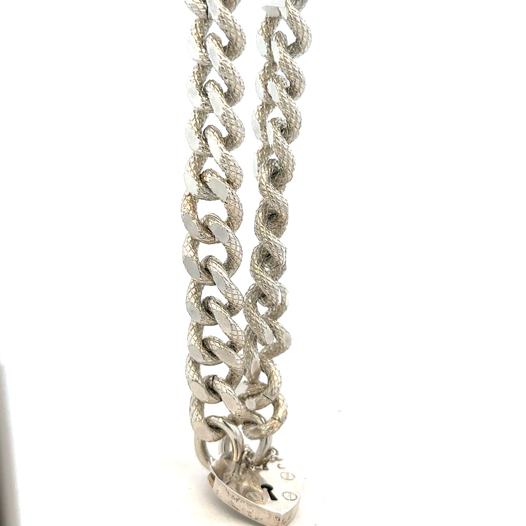 Silver bracelet weighing 64.4g with intricate design, unbranded jewelry piece displayed on a plain background.