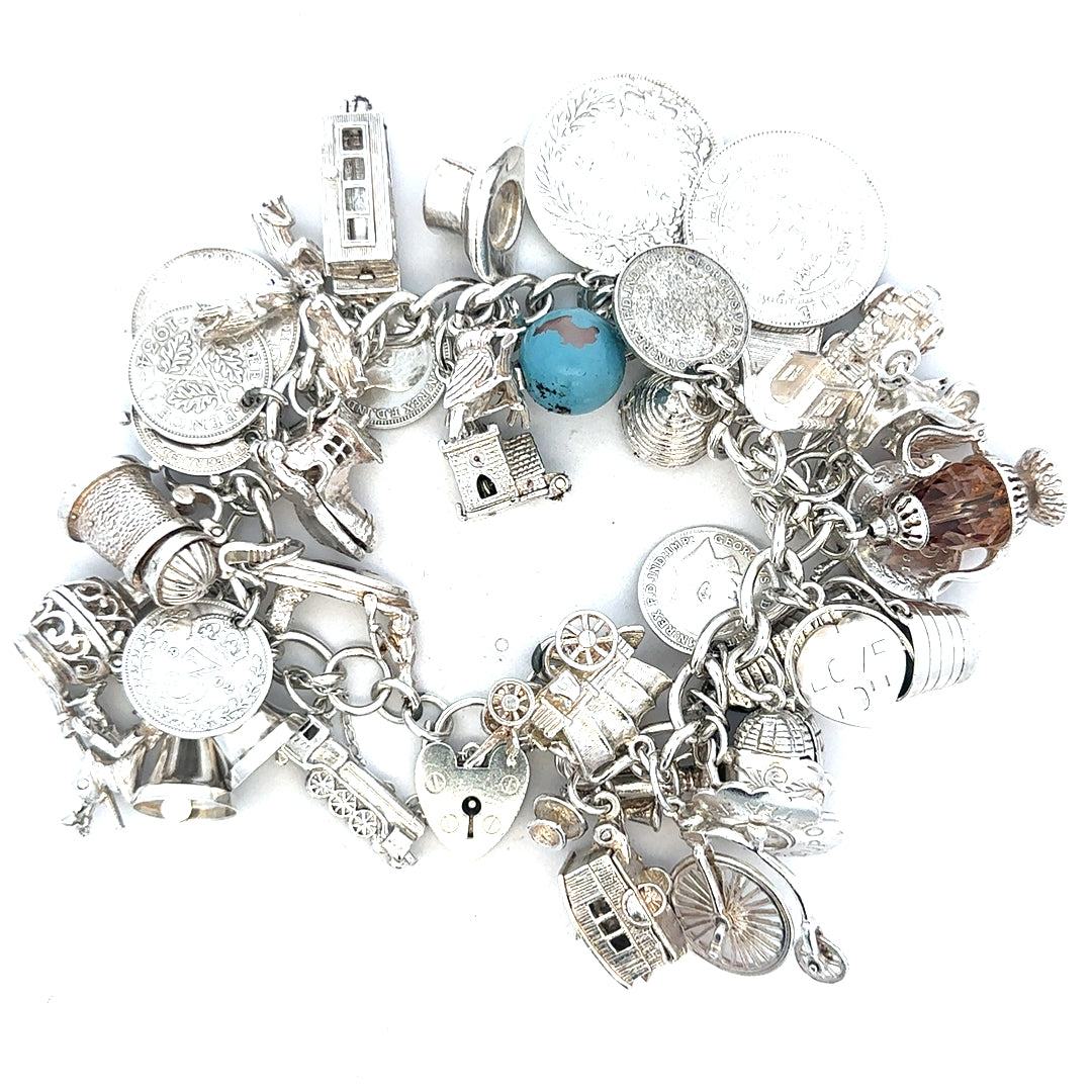 Silver charm bracelet weighing 128.8g with intricate charms, crafted in sterling silver for a stylish accessory.