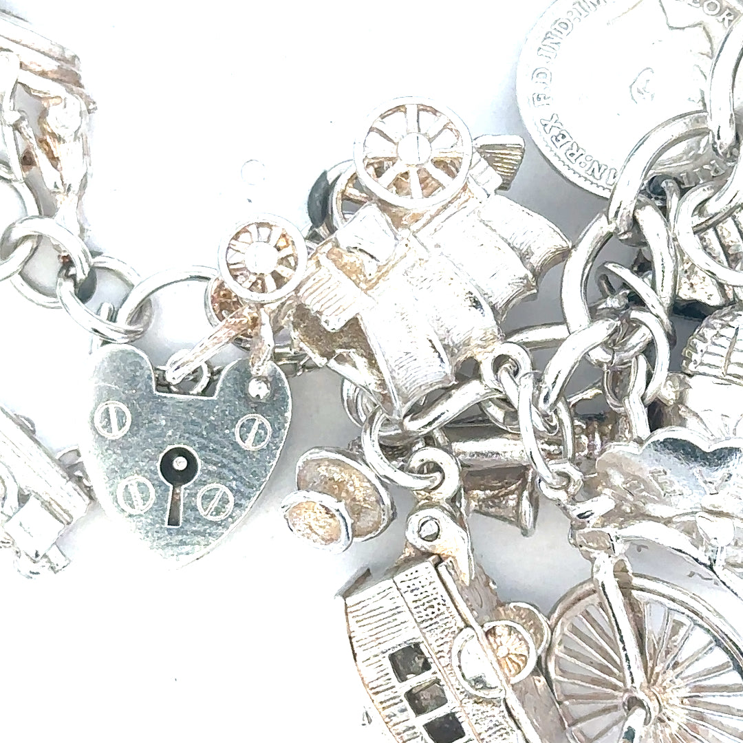 Silver charm bracelet weighing 128.8g with various decorative charms, unbranded jewelry accessory.