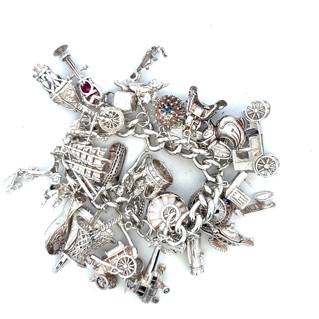 Silver charm bracelet weighing 154.4g with various decorative charms, unbranded jewelry accessory, detailed close-up shot.