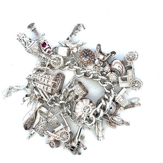 Silver charm bracelet weighing 154.4g with various decorative charms, unbranded jewelry accessory, detailed close-up shot.
