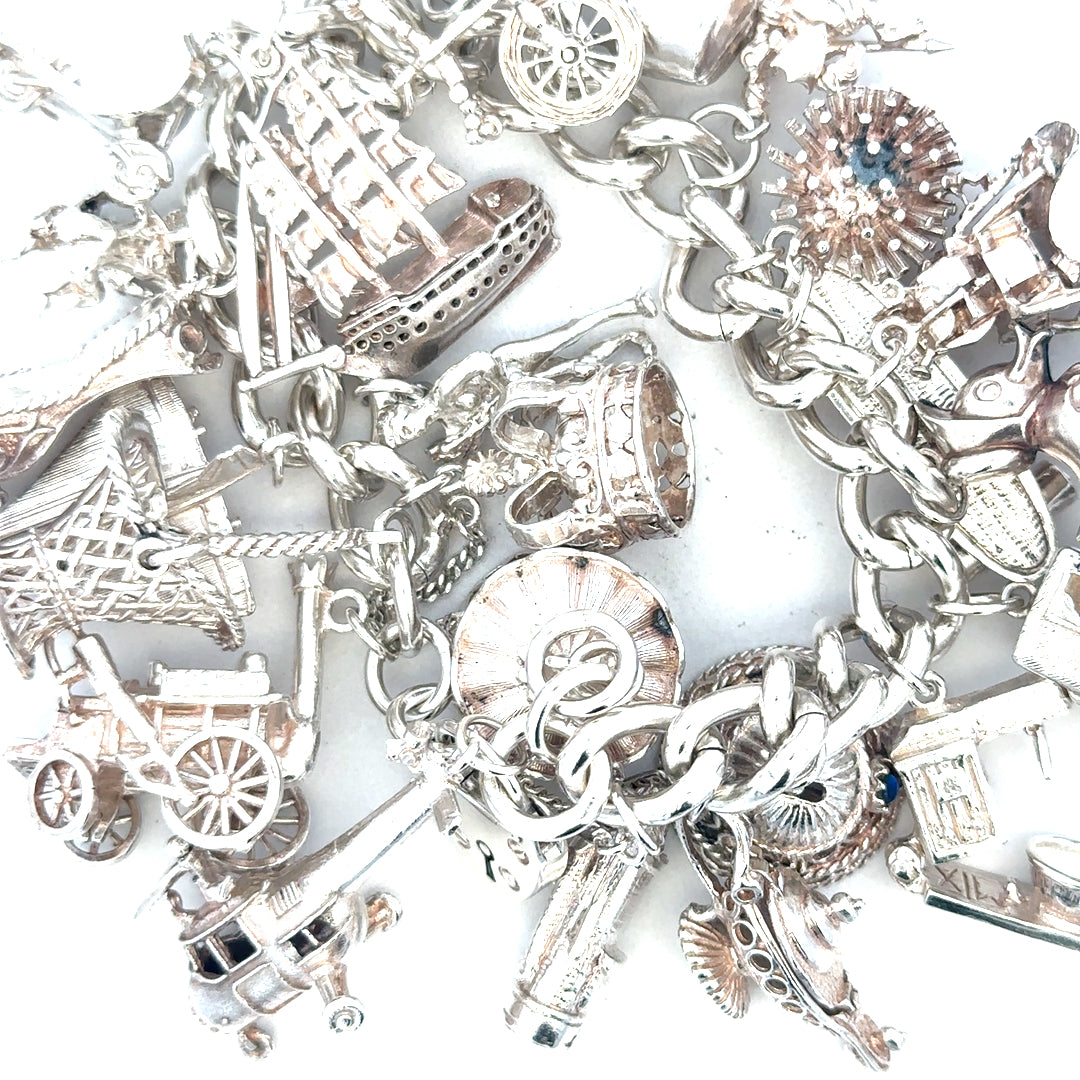 Silver charm bracelet weighing 154.4g with intricate charms and links, unbranded jewelry accessory for stylish wear.