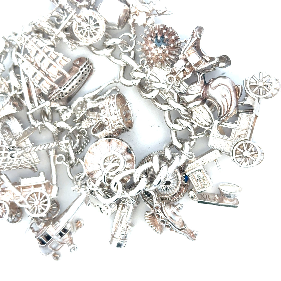 Silver charm bracelet weighing 154.4g with various charms, unbranded jewelry accessory, detailed close-up of the bracelet.
