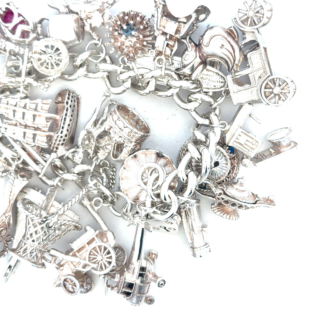 Silver charm bracelet weighing 154.4g with various charms, unbranded jewelry accessory, detailed close-up shot.