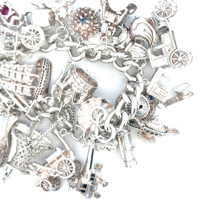 Silver charm bracelet weighing 154.4g with various charms, unbranded jewelry accessory, detailed close-up shot.