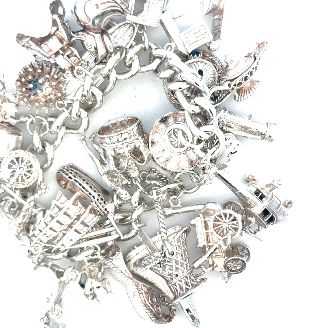 Silver charm bracelet weighing 154.4g with multiple decorative charms, displayed on a neutral background.