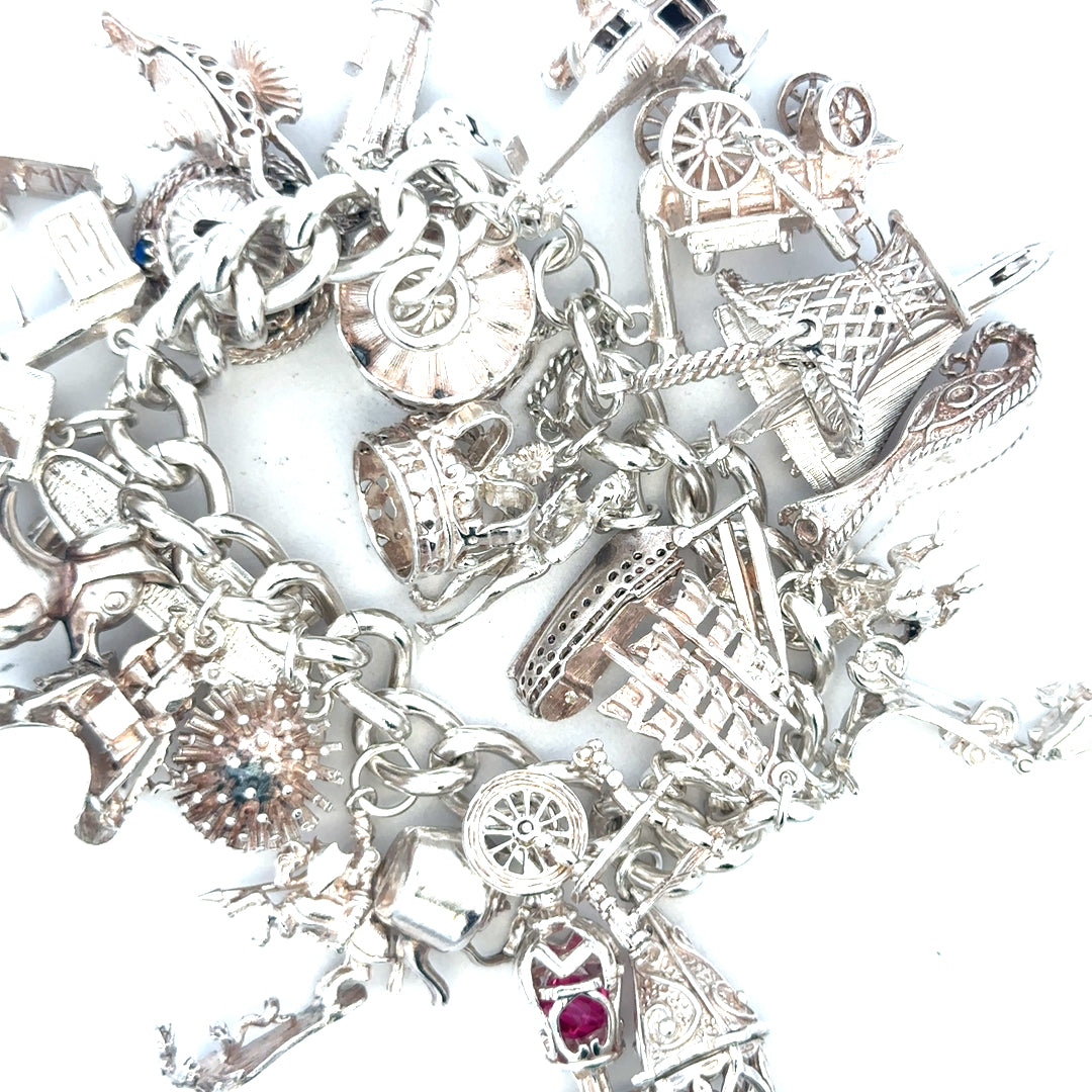 Silver charm bracelet weighing 154.4 grams with various charms, featuring a sleek unbranded design in the image.
