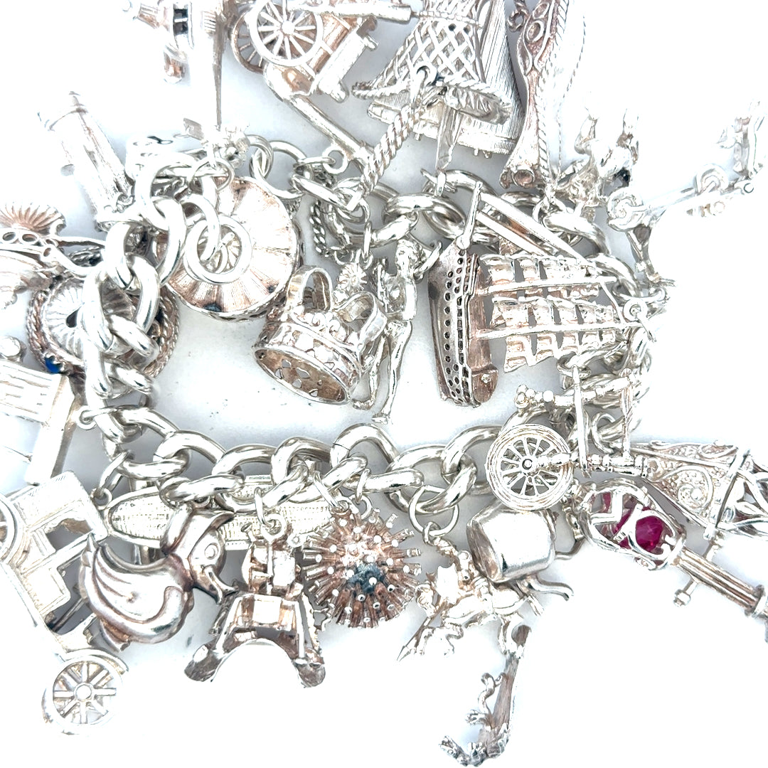 Silver charm bracelet weighing 154.4g with various decorative charms, unbranded jewelry accessory, detailed and stylish.