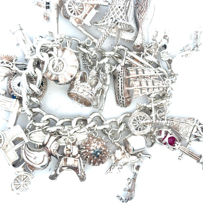 Silver charm bracelet weighing 154.4g with various decorative charms, unbranded jewelry accessory, detailed and stylish.
