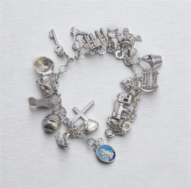 Silver charm bracelet with intricate designs, weighing 45.9 grams, featuring various decorative charms and a secure clasp.