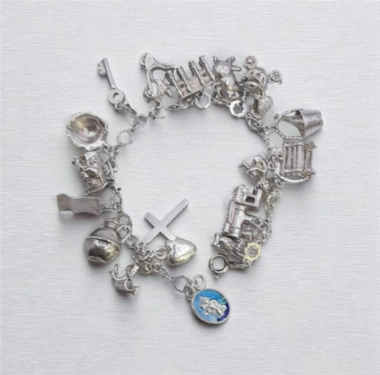 Silver charm bracelet with intricate designs, weighing 45.9 grams, featuring various decorative charms and a secure clasp.