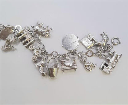 Silver charm bracelet weighing 45.9g with various decorative charms, crafted from high-quality silver.